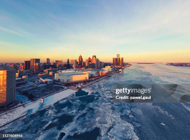 aerial view of frozen detroit river with city skyline in winter - michigan winter stock pictures, royalty-free photos & images