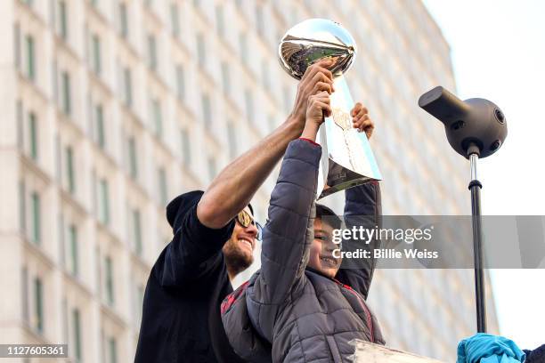 Tom Brady of the New England Patriots holds the Vince Lombardi trophy with his son Benjmain Brady during the Super Bowl Victory Parade on February...