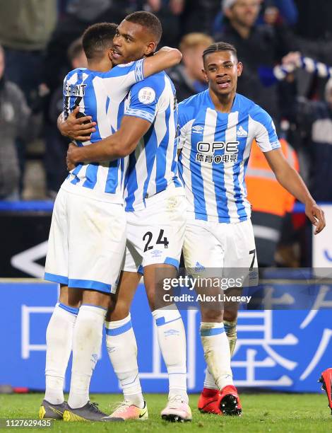 Steve Mounie of Huddersfield Town celebrates after scoring his team's first goal with team mates during the Premier League match between Huddersfield...