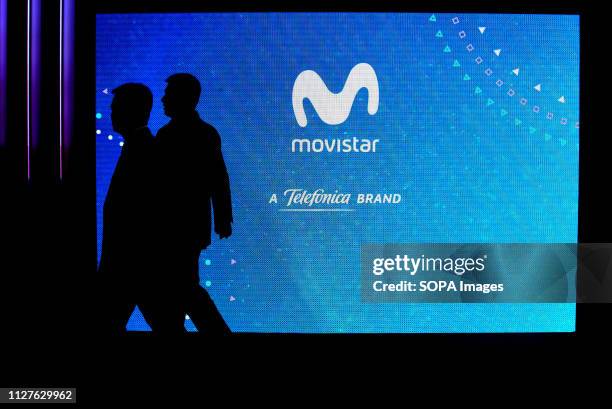 Two visitors are seen walking in front of the Movistar stand at the Mobile World Congress in Barcelona.