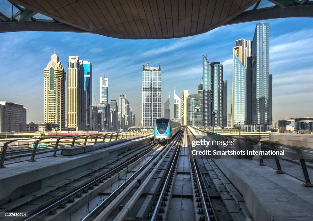 Dubai driverless metro with futuristic city skyline on background in Dubai, UAE