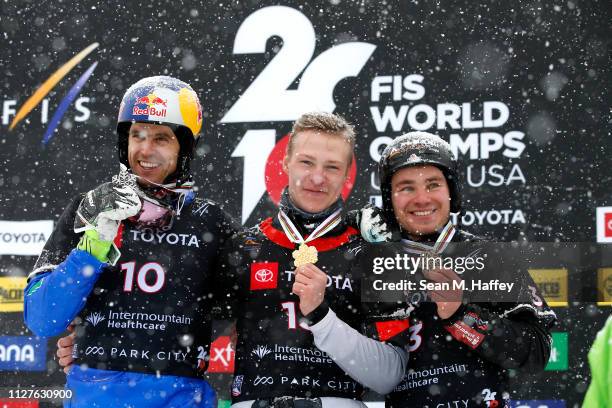 Roland Fischnaller of Italy second place, Dmitry Loginov of Russia first place, and Stefan Baumeister of Germany third place celebrate on the podium...