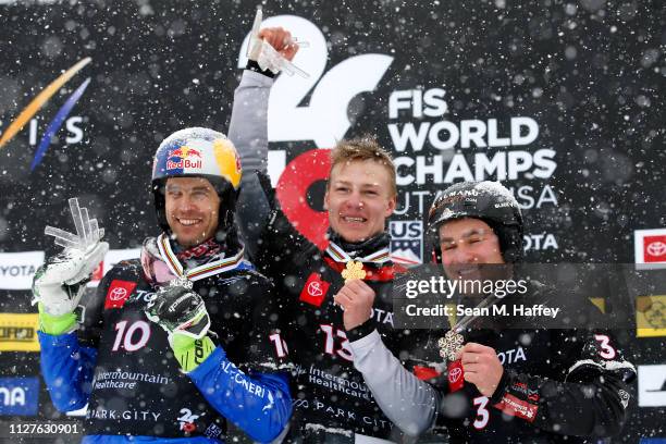 Roland Fischnaller of Italy second place, Dmitry Loginov of Russia first place, and Stefan Baumeister of Germany third place celebrate on the podium...