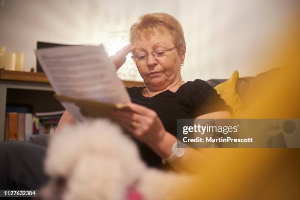 orolig senior kvinna läsa brev - grandma invoice bildbanksfoton och bilder