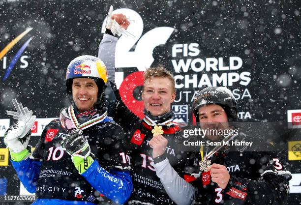 Roland Fischnaller of Italy second place, Dmitry Loginov of Russia first place, and Stefan Baumeister of Germany third place celebrate on the podium...