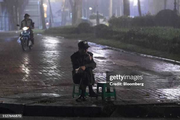 Man lights a cigarette at night in Hanoi, Vietnam, on Tuesday, Feb. 26, 2019. The White House has set low ambitions for Thursday's talks, organized...
