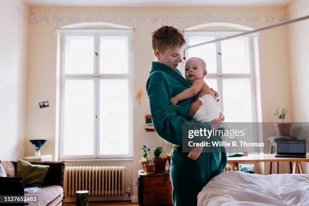 single mother holding baby in morning - androgynous boys stock pictures, royalty-free photos & images