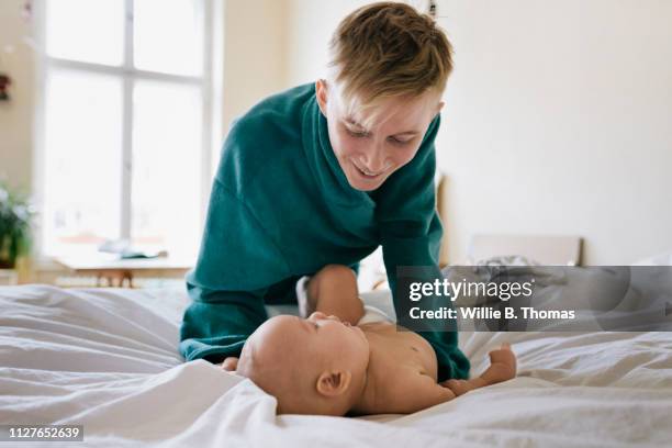 single mother getting baby ready in morning - androgynous boys stock-fotos und bilder