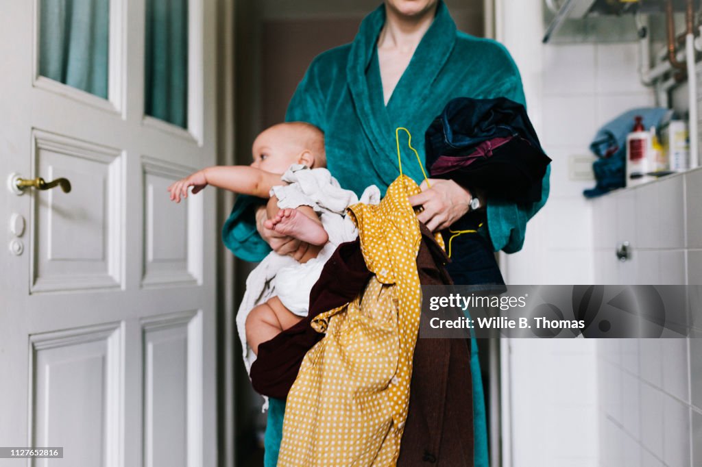 Single Mother With Baby Trying To Get Dressed