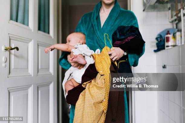 Single Mother With Baby Trying To Get Dressed