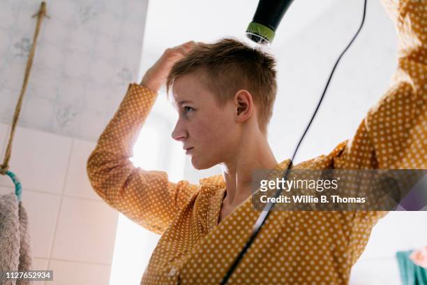 single mother drying her hair - short hair stock pictures, royalty-free photos & images