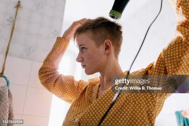 single mother drying her hair - androgynous 個照片及圖片檔