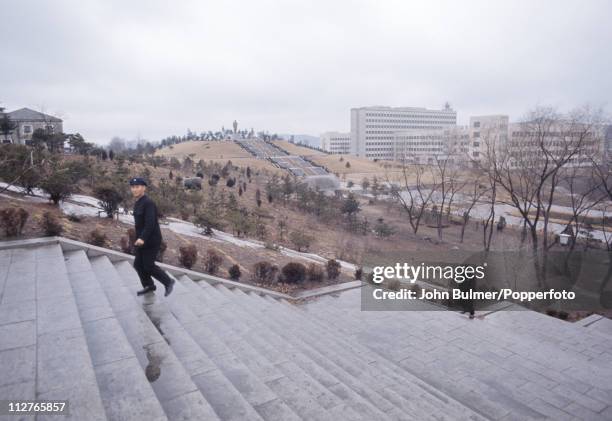 Two men walking up a flight of steps, North Korea, February 1973.