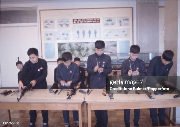 Group of boys assembling assault rifles, North Korea, February 1973.