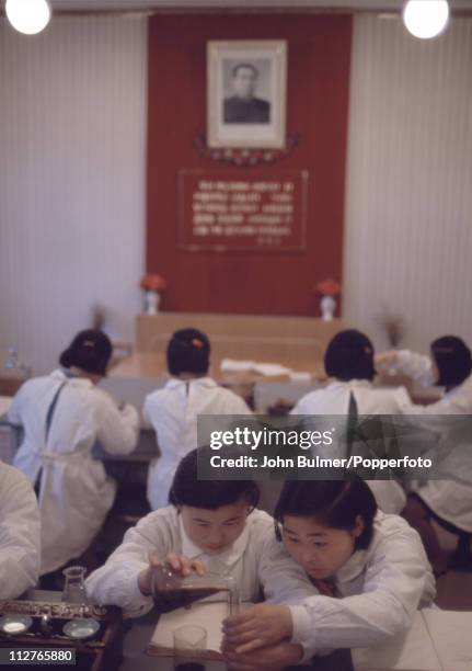 Group of girls in a chemistry class, North Korea, February 1973. On the wall is a portrait of North Korea's Eternal President of the Republic Kim...