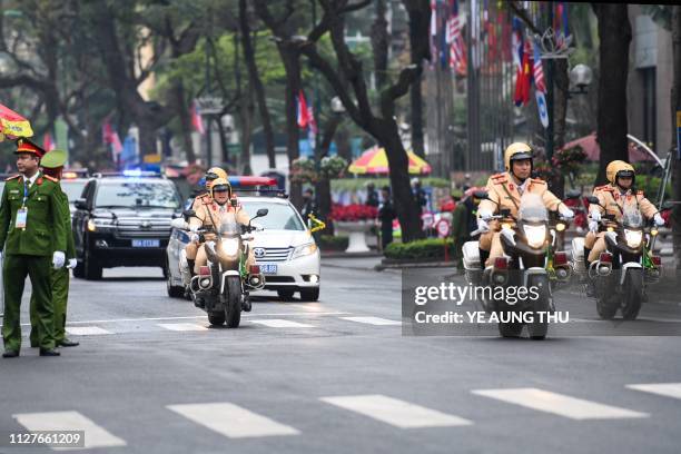 Vietnamese policemen escort a motorcade out of the Melia hotel on February 27 ahead of the second US-North Korea summit. - US President Donald Trump...