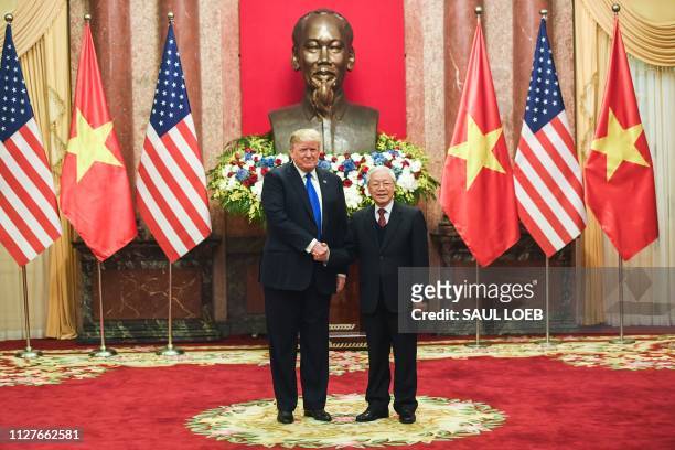 President Donald Trump shakes hands with his Vietnamese counterpart Nguyen Phu Trong before a meeting at the Presidential Palace in Hanoi on February...