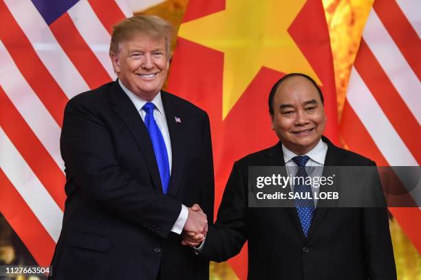 President Donald Trump shakes hands with Vietnam's Prime Minister Nguyen Xuan Phuc befoer a meeting at the Government Office in Hanoi on February 27...