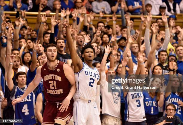 Nik Popovic of the Boston College Eagles and Cam Reddish of the Duke Blue Devils watch as a three-point shot by Reddish drops through the net during...