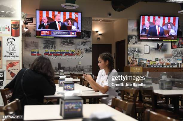 Silvia Lara and Isabella Lara visit the El Original EL Arepazo restaurant as a television broadcasts U.S. President Donald Trump as he delivers his...