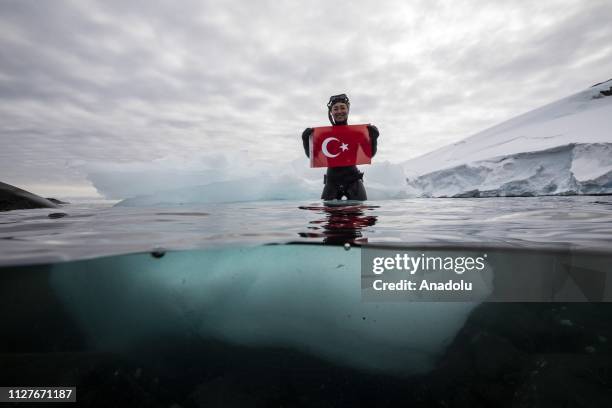 Sahika Ercumen, an internationally renowned Turkish diver, holds a flag of Turkey as she stands on an iceberg during her free-diving, marking the...