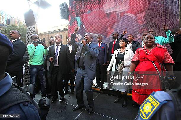 President Julius Malema , flanked by ANC members including Winnie Madikizela-Mandela , speaks to supporters outside the high court on April 20, 2011...