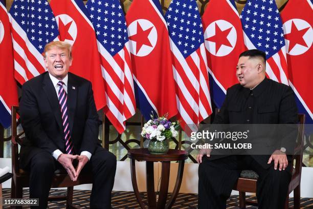 President Donald Trump speaks as North Korea's leader Kim Jong Un looks on during a meeting at the Sofitel Legend Metropole hotel in Hanoi on...