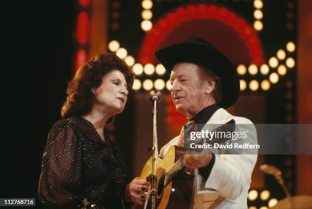 Kitty Wells, U.S. Country singer, and her husband, country music singer Johnnie Wright, in concert, singing together with Wright playing a guitar,...