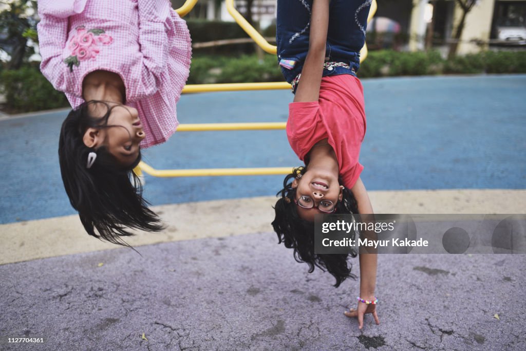 Girl upside down on the jungle gym