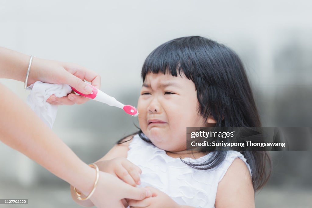 Adorable girl against practice or learning for brush teeth.
