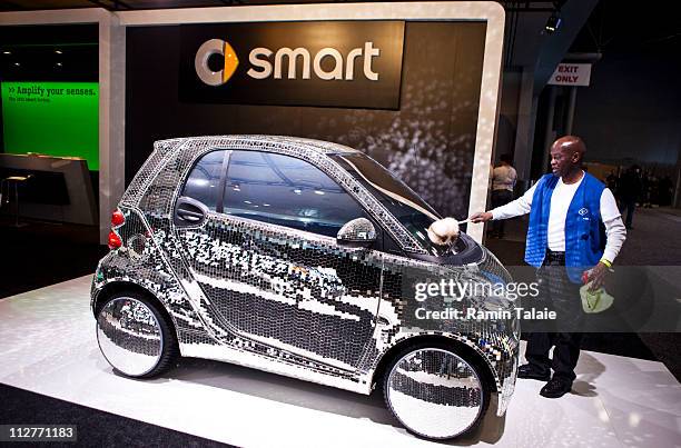 Man cleans a disco-ball concept Smart Car during the New York International Auto Show April 21, 2011 in New York City. The New York Auto Show is one...