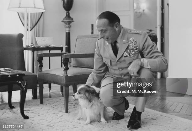 American Army general Lyman Lemnitzer , Supreme Allied Commander Europe of NATO, with a small sized dog, UK, 8th August 1963.