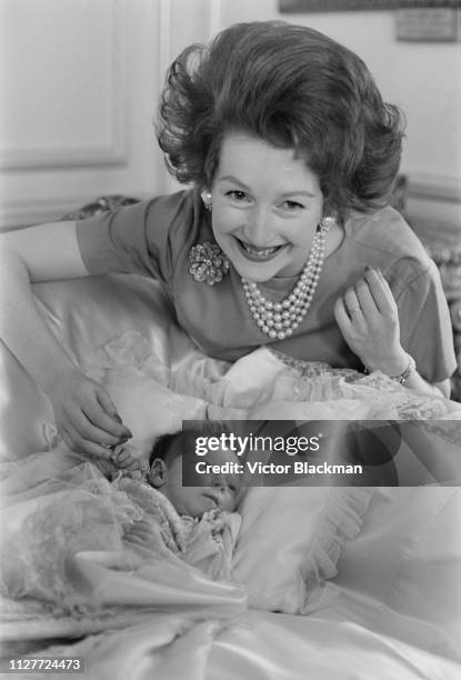 British socialite and local politician Raine Spencer, Countess Spencer with her baby daughter, Lady Charlotte Legge, UK, 9th August 1963.