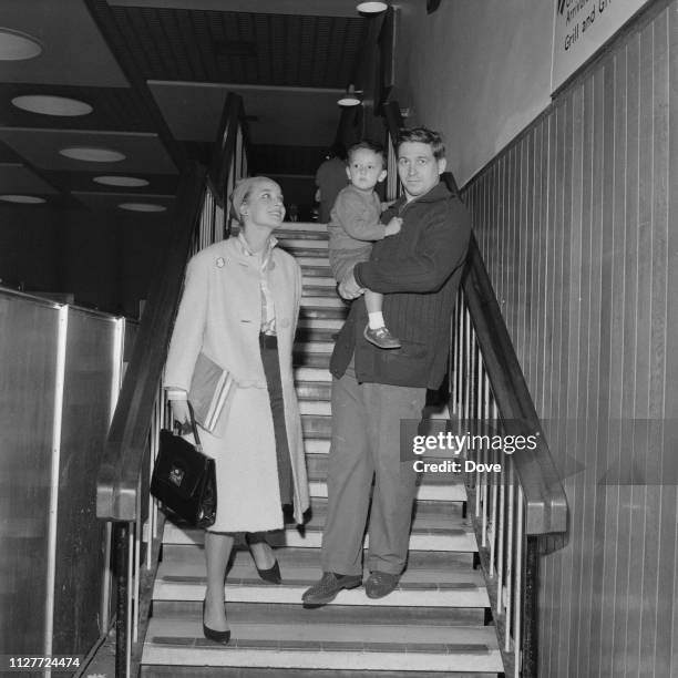 English actress Sylvia Syms with her husband Alan Edney and their son Benjamin Edney at Heathrow Airport, London, UK, 12th August 1963.