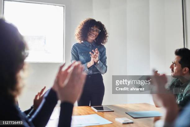 young businesswoman applauded by peers - applauding leader stock pictures, royalty-free photos & images