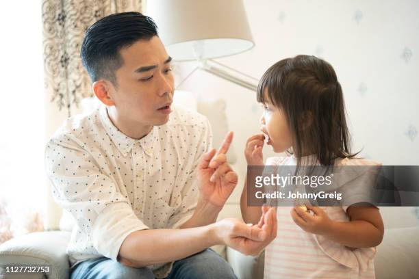 father telling off his young daughter - strict parent imagens e fotografias de stock