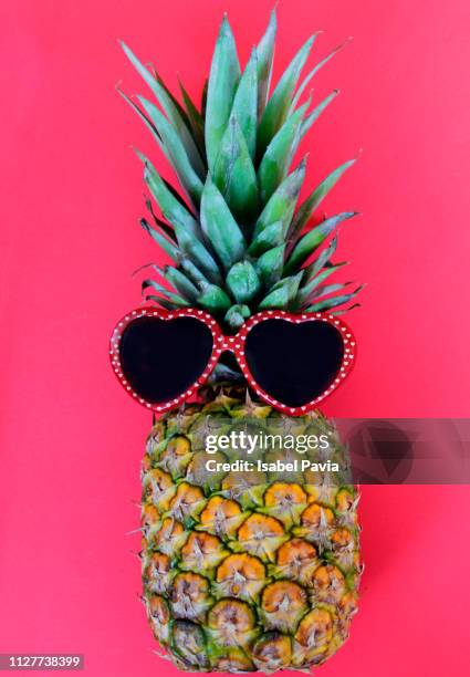 pineapple with red heart shape sunglasses on red background - comedy club stock pictures, royalty-free photos & images