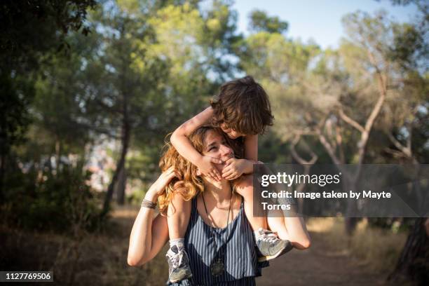 mom carrying baby boy on her shoulders - fashionable kids stock pictures, royalty-free photos & images