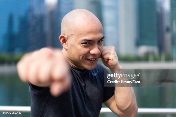 asian chinese fitness instructor, fist of confidence - martial arts man stock pictures, royalty-free photos & images