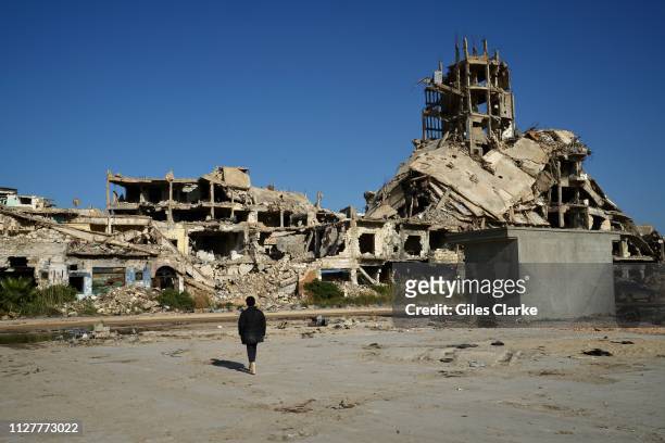 Boy stands before ruins in Benghazi's old city on February 4, 2019 in Libya. After the Libyan revolution in 2011 and the downfall of the Gaddafi...