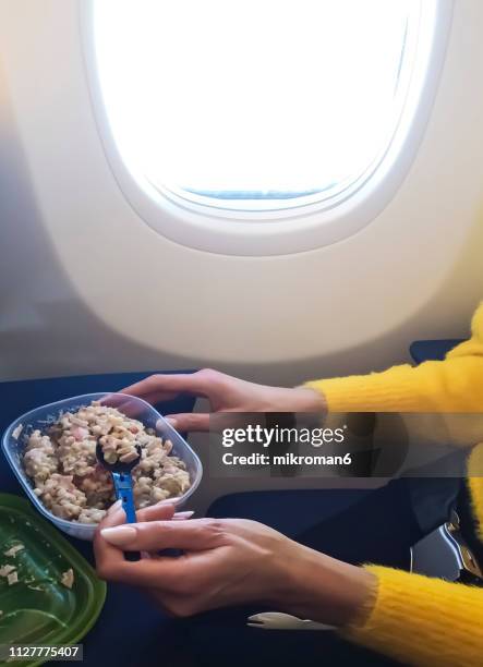 woman eating meal in airplane - airline food stock-fotos und bilder