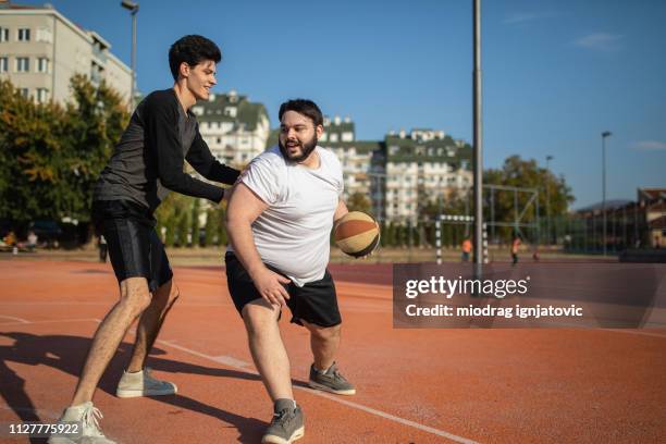 zwei basketballspieler auf dem platz - fat guy running stock-fotos und bilder