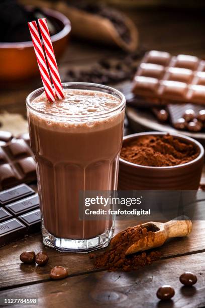 hausgemachte schokolade milchshake schüsse aufs holz küchentisch - milchshake stock-fotos und bilder
