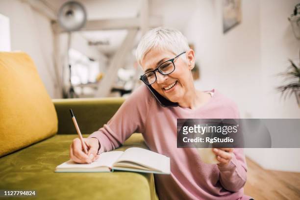 gelukkige vrouw praten over de telefoon - happy old women stockfoto's en -beelden
