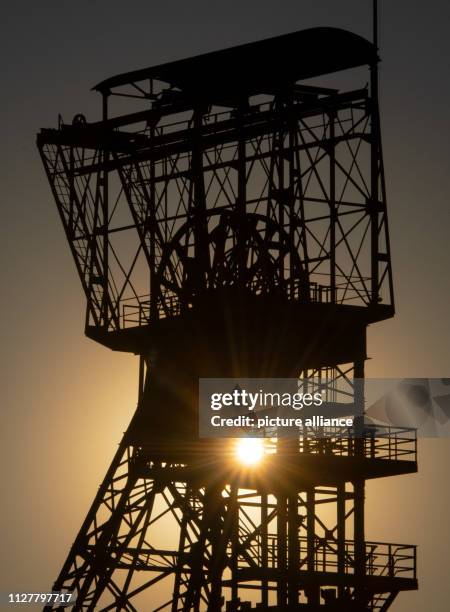 February 2019, North Rhine-Westphalia, Dortmund: The sun sets behind a winding tower of the former Zollern colliery. Photo: Bernd Thissen/dpa