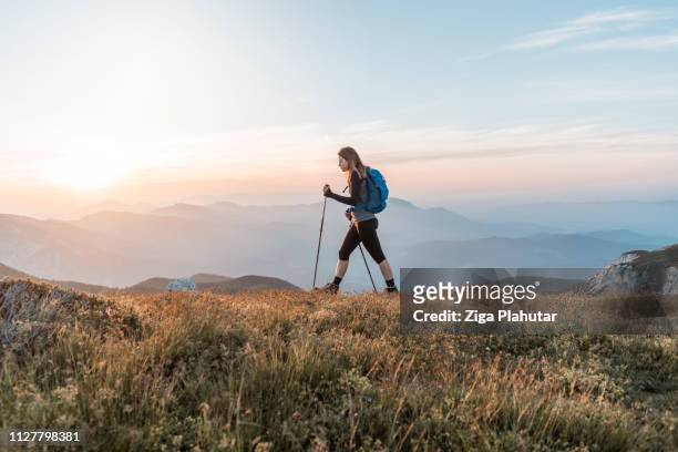 mujeres jóvenes subiendo la colina - senderismo fotografías e imágenes de stock
