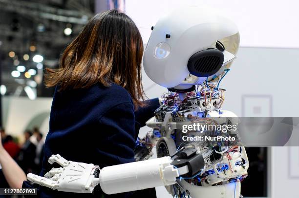 Congress attendant give a hug a Roboy 2.0 the only robot that imitates the human body structure, exhibited during the Mobile World Congress, on...