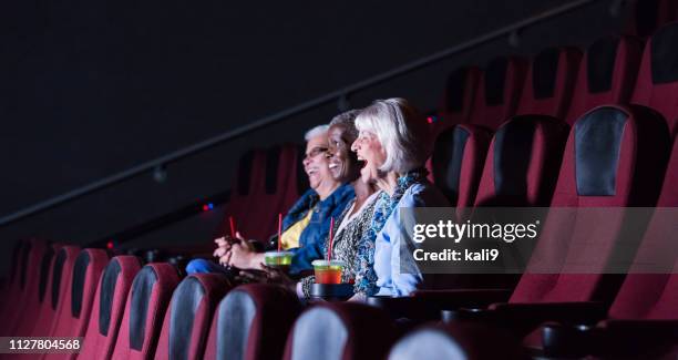 multi-etnische senior vrouwen in bioscoop film kijken - girlfriends films stockfoto's en -beelden