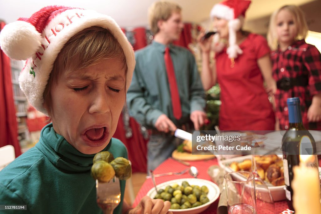 Boy tasting sprouts at christmas table