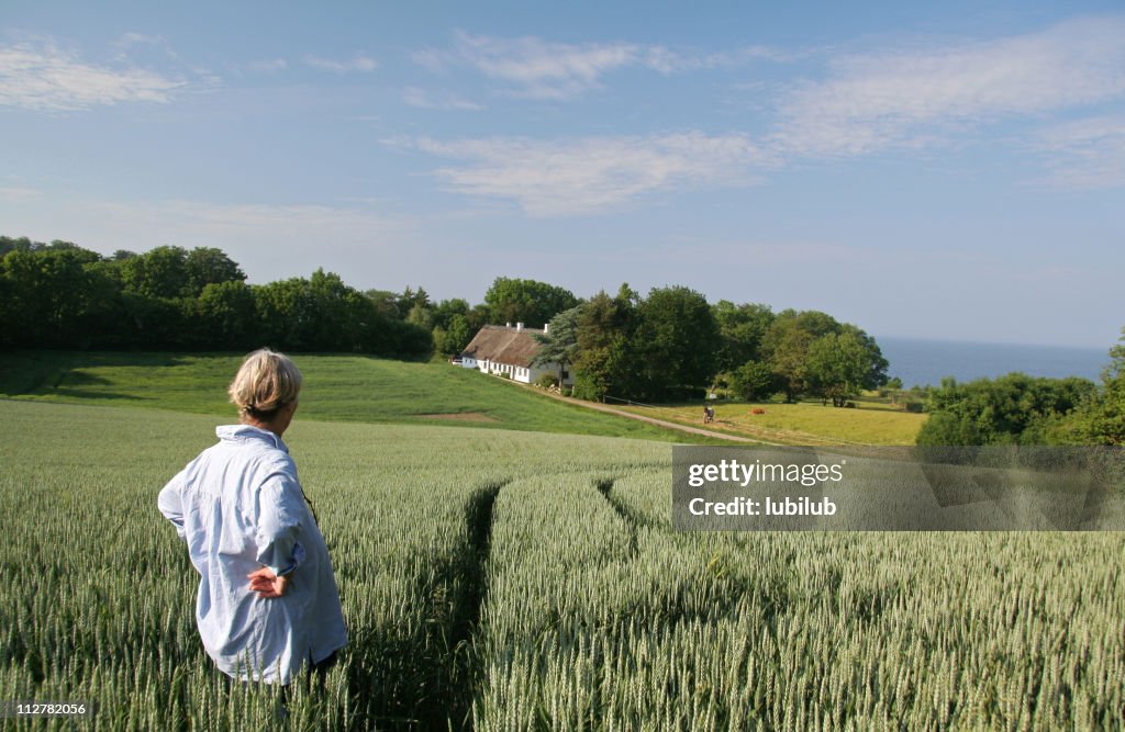 Woman enjoying her  beautiful land and house in  Denmark